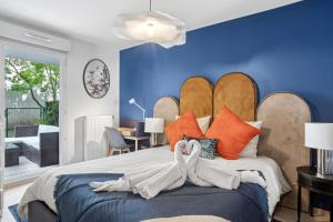 a bedroom with a large bed with blue walls at Retro-chic elegance with terrace near tramway - AC in Saint-Priest