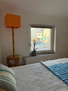 a bedroom with a bed with a lamp and a window at Studio dwupokojowe z łazienką i kuchnią in Augustów