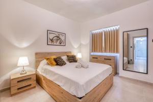 a bedroom with a large bed and a mirror at Amazing apartment with pool in Malta in Is-Swieqi +55 photos