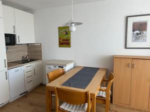 a kitchen with a wooden table and a kitchen with white cabinets at Ferienwohnung Predigtstuhl Resort in Sankt Englmar