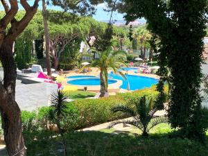 ein Resort mit zwei Pools mit Palmen und Büschen in der Unterkunft Detached Villa on Balaia Golf Village with Golf & Tennis, walking distance to Beach and many Bars and Restaurants in Olhos de Água