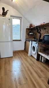 a kitchen with a refrigerator and a washing machine at В гостях у Лексо in Mukhatgverdi