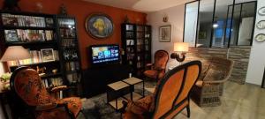 a living room with several chairs and a television at Les Carmes in Langres
