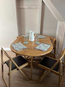 a wooden table with two chairs and a vase on it at Katys Cottage, Barnoldswick in Barnoldswick +9 photos