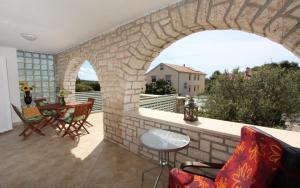 a patio with a stone wall and a table and chairs at Apartments Monpeloso in Rovinj
