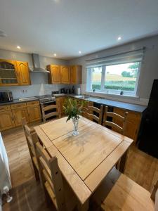 a kitchen with a wooden table with chairs and a window at Samieston Lodge, near Jedburgh in Whitton