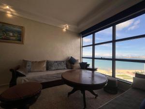 una sala de estar con un sofá y una mesa en Tout à pied - vue mer et plage, en Tánger