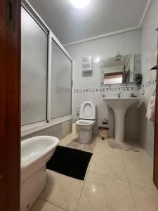 Un baño con un lavabo y un inodoro y un lavabo. en Tout à pied - vue mer et plage, en Tánger