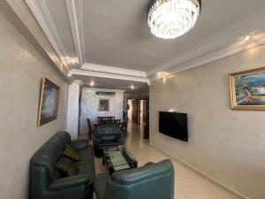 Una sala de estar con un sofá y un televisor de pantalla plana. en Tout à pied - vue mer et plage, en Tánger