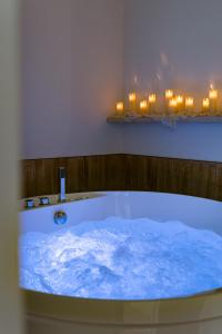 a bath tub filled with blue water next to candles at La Suite Saint Georges in Lyon