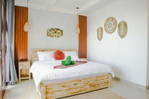 a bedroom with a white bed with a wooden frame at LA Beach Nusa Penida in Nusa Penida