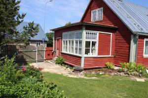 a red house with a window in a yard at Suur-Lossi Apartments in Haapsalu