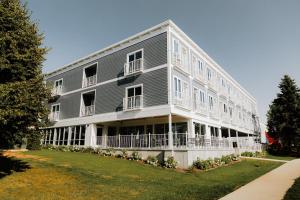 a large apartment building with a lawn in front of it at Dexter Hotel in Elk Rapids +24 photos