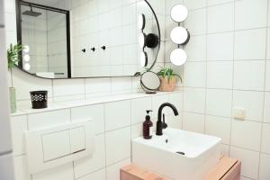Un baño blanco con lavabo y espejo. en stycoz - Modern studio - Central, en Kempten