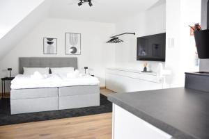 Un dormitorio blanco con una cama y un televisor. en stycoz - Modern studio - Central, en Kempten