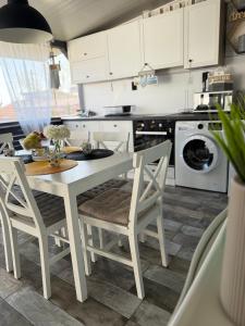 a kitchen with a white table and chairs at La Veranda Sinemorets in Sinemorets