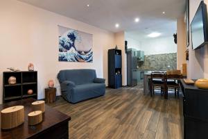 ein Wohnzimmer mit einem blauen Stuhl und einem Tisch in der Unterkunft La piuma apartment in Quartu SantʼElena