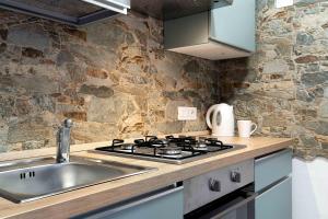 eine Küche mit Spüle und Herd in der Unterkunft La piuma apartment in Quartu SantʼElena