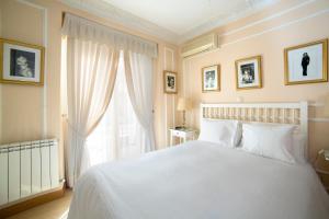 sypialnia z białym łóżkiem i oknem w obiekcie Hostal Adriano w Madrycie