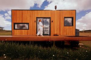 a tiny house on a dock with a person standing in the doorway at É diferente, descubra por quê in Urubici