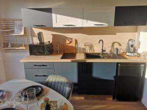 a kitchen with a counter with a sink and a table at Studio in Blosville