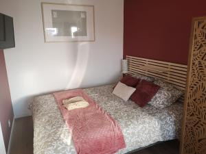 a small bedroom with a bed with two pillows at Studio in Blosville