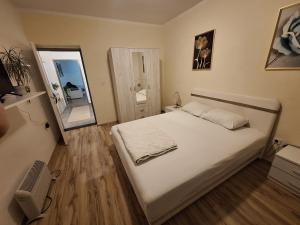 a bedroom with a large white bed and a mirror at Vavic 2 in Topla
