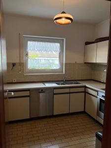 una cocina con fregadero y ventana en Küstenbude große Auszeit, en Grömitz