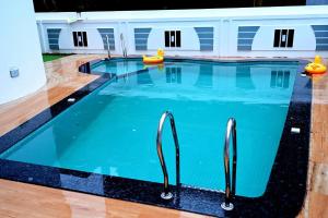 an indoor swimming pool with blue water and wooden floors at White House by Taneja Luxury Homes in Navelim