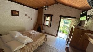 una camera da letto con un letto in una stanza con una finestra di Vale do Piemonte - Chalé com hidromassagem - a Santo Antônio do Pinhal