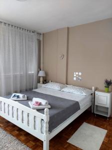 a bedroom with a large white bed in a room at Apartman Maja in Banja Luka