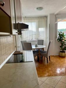 a kitchen and dining room with a table and chairs at Apartman Maja in Banja Luka