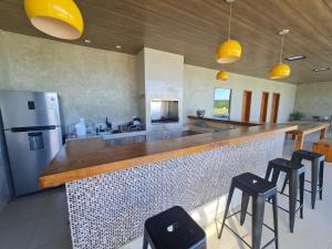 a kitchen with a counter with stools and a refrigerator at Mol Residence in Esmeraldas