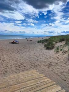 a beach with people laying on the sand and the ocean at GRANDE PLAGE A 50 Métres in Valras-Plage