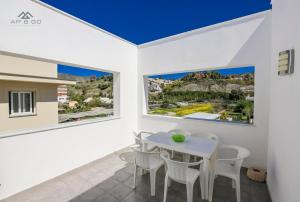 een eetkamer met een witte tafel en stoelen en 2 ramen bij House Beach Park in La Herradura