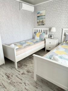 a bedroom with two beds and a brick wall at La Veranda Sinemorets in Sinemorets