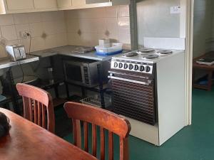 a kitchen with a stove and a table with chairs at Unit 15 The Stables in Harefield