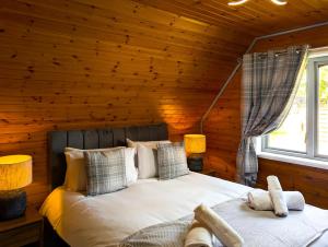 een slaapkamer met een bed in een blokhut bij Cear 2- Private Hot Tub- Perth-Pet Friendly Lodge in Almondbank