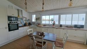 a kitchen with a table and chairs in a kitchen at Maison Mer Louis in Saint-Pierre-dʼOléron