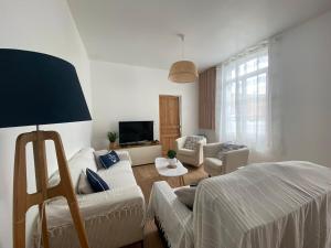 una sala de estar con un sofá y una mesa en Maison Mer Louis, en Saint-Pierre-dʼOléron