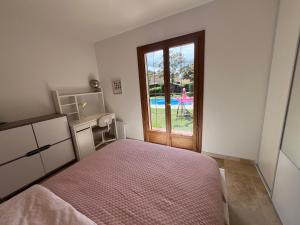 una camera da letto con un letto e una porta scorrevole in vetro di Charming Provençal Villa with pool and garden a Mougins Altre 37 foto