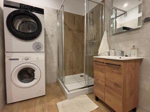 a bathroom with a washing machine and a washer at Apartament u Wojtusia in Stronie Śląskie
