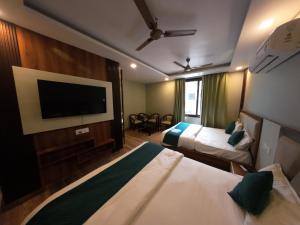 a hotel room with two beds and a flat screen tv at Yatram in Rishīkesh