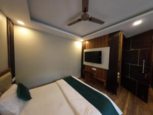 a bedroom with a bed and a flat screen tv at Yatram in Rishīkesh