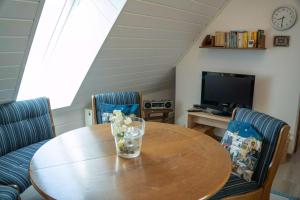 a dining room with a table with chairs and a television at Landhaus Birkenhof in Varel