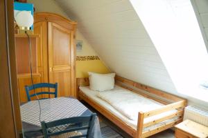 a small room with a bed and a chair at Landhaus Birkenhof in Varel