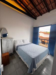 a bedroom with a bed and a large window at Guaecá Hostel - Cumuruxatiba in Cumuruxatiba