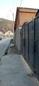 a fence on the side of a building next to a street at Гостиница Али in Akchiy