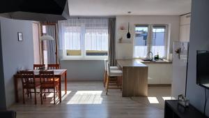 a kitchen and living room with a table and chairs at Apartament na Uboczu in Wągrowiec