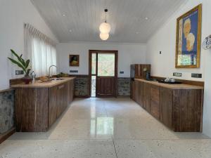 a large kitchen with wooden cabinets and a window at Blackwoods FarmHouse in Beragala